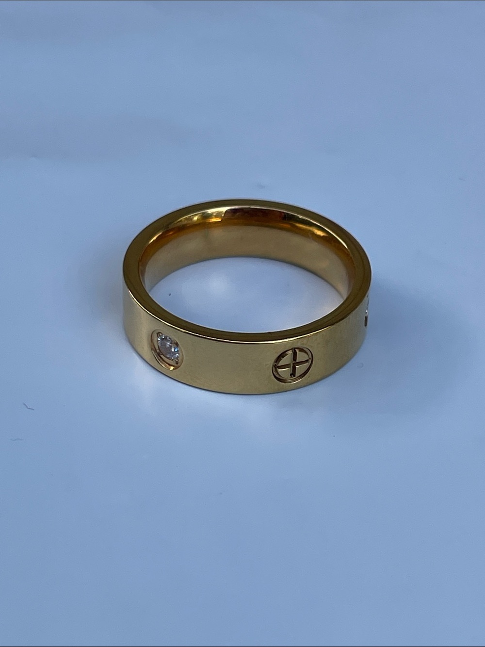 Gold Band Ring with Clear Stone and Circular Emblem